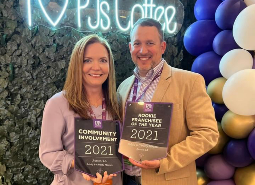 Bobby and Kristy Mounts stand side by side, holding their PJ's Coffee Rookie of the Year and Community Involvement awards for 2021.